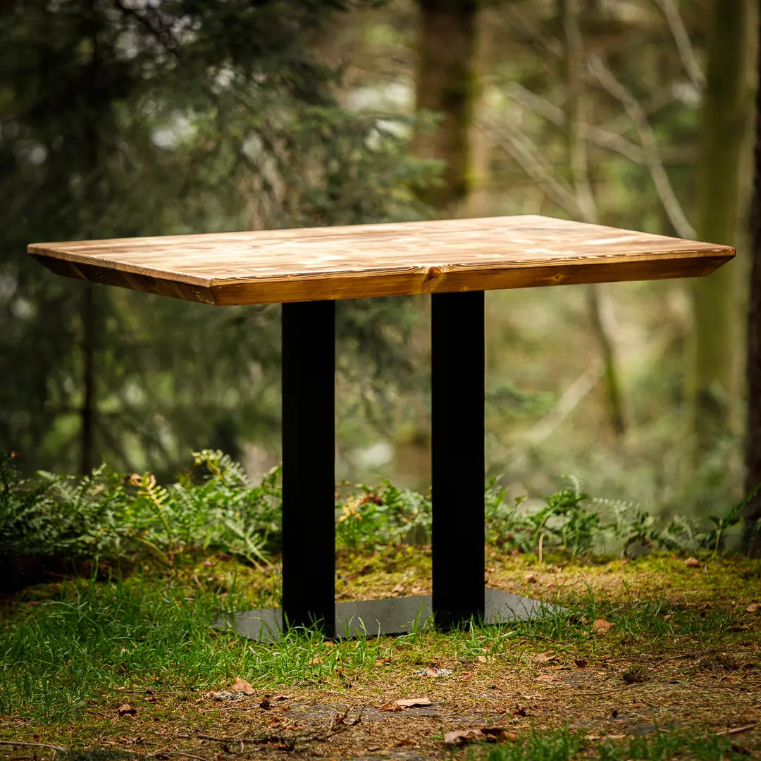 Geflammter Gastro-Tisch mit Metallgestell, der im Wald steht